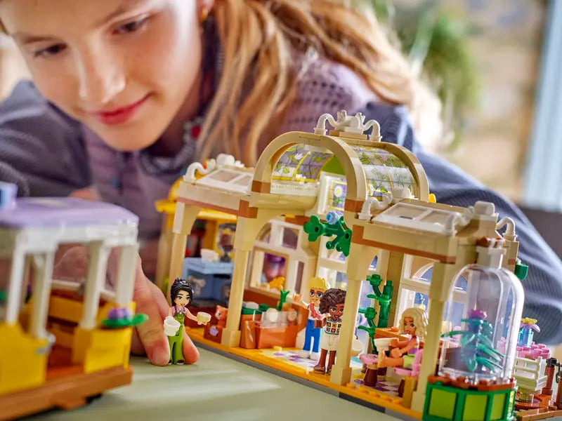 Kid playing with LEGO® Friends Plant Café & Flower Shop 42671