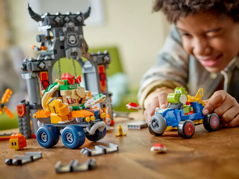 Kid playing with LEGO Super Mario 72039 Mario Kart – Bowser's Castle