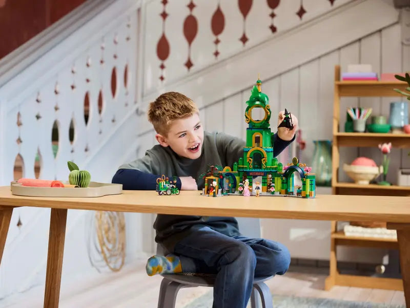 A kid playing with LEGO® Wicked 75684 Welcome to Emerald City