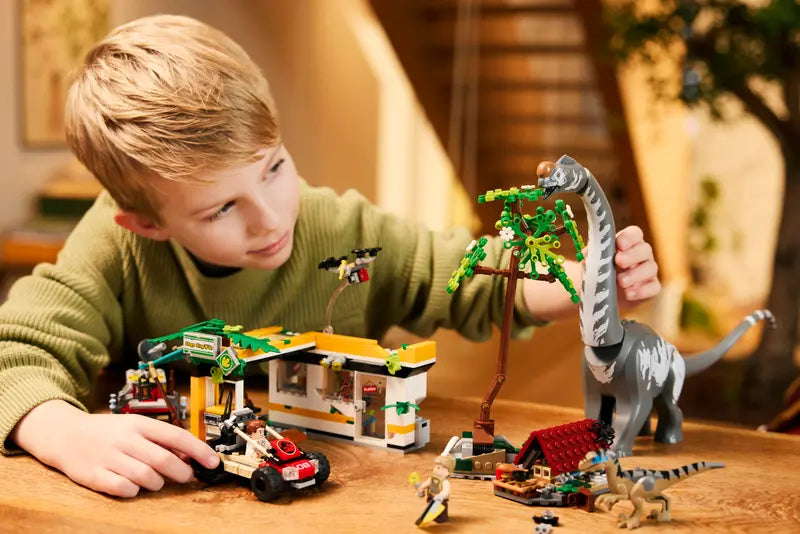 Kid playing with LEGO Jurassic World Raptor & Titanosaurus Tracking Mission 76973