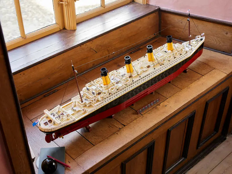 LEGO® ICONS Titanic 10294 displayed on a shelf next to a window