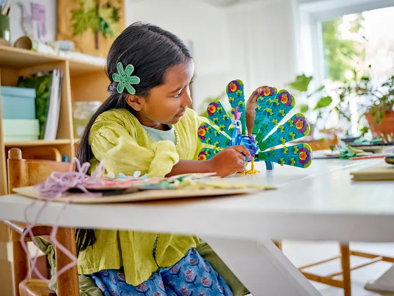 Kid playing with LEGO Creator 3in1 Exotic Peacock 31157