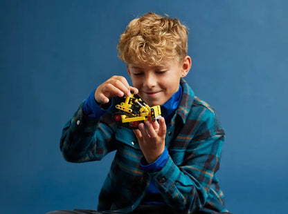 Kid playing with LEGO Technic Heavy-Duty Bulldozer 42163 